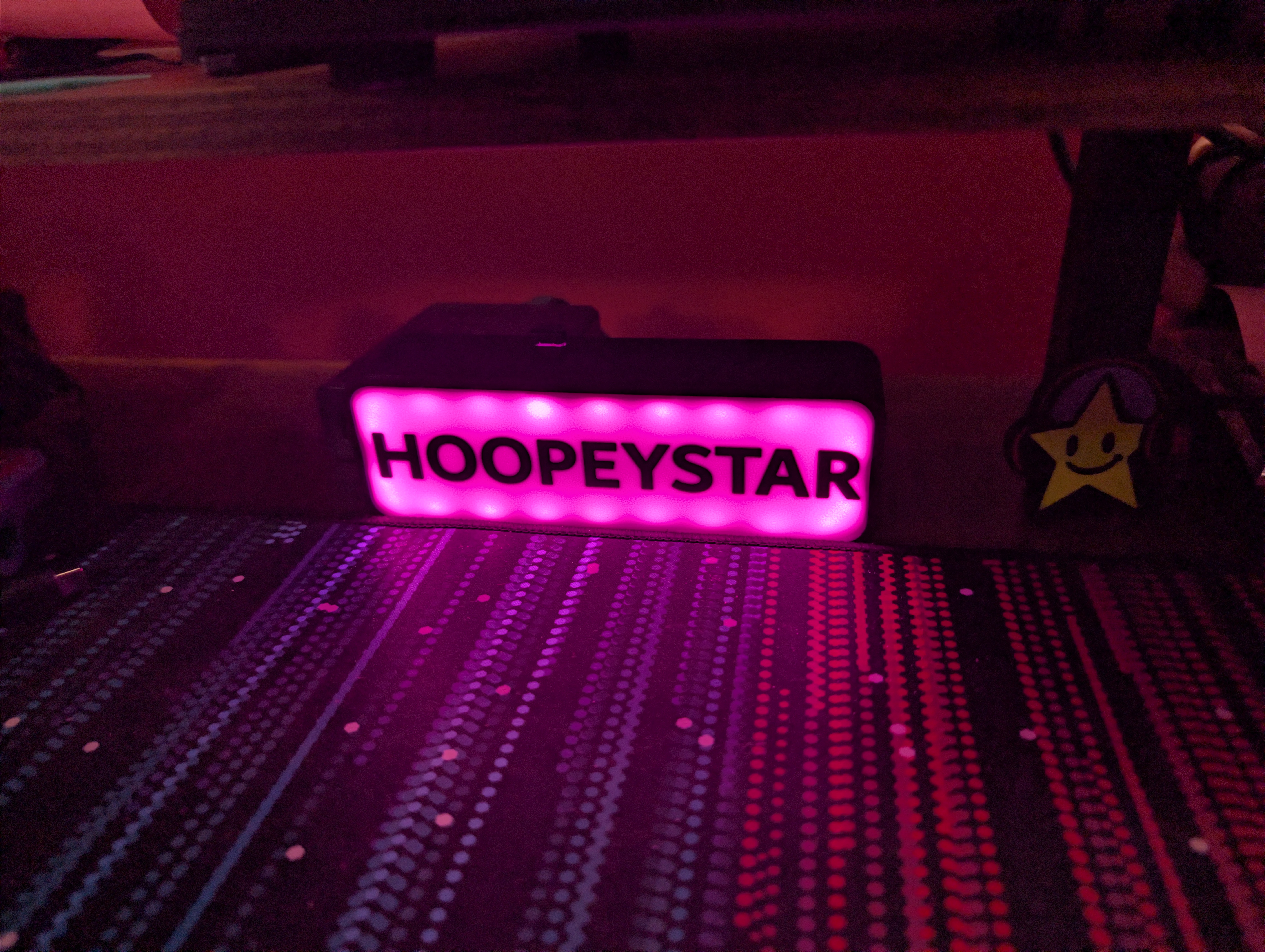 Pink Hoopeystar LED sign on desk